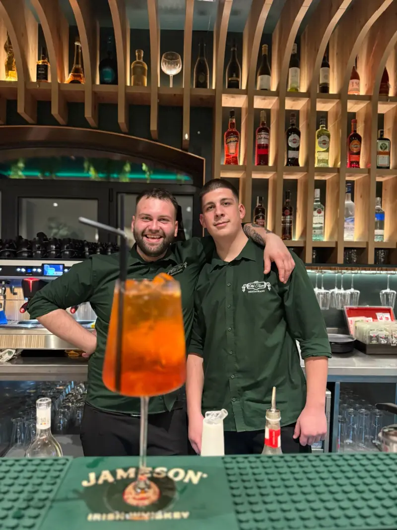 Barul Old Town cu cocktailuri, echipa în uniforme verzi